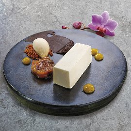 Cheesecake podávaný so zaváraninou, polevou ganache a zmrzlinou